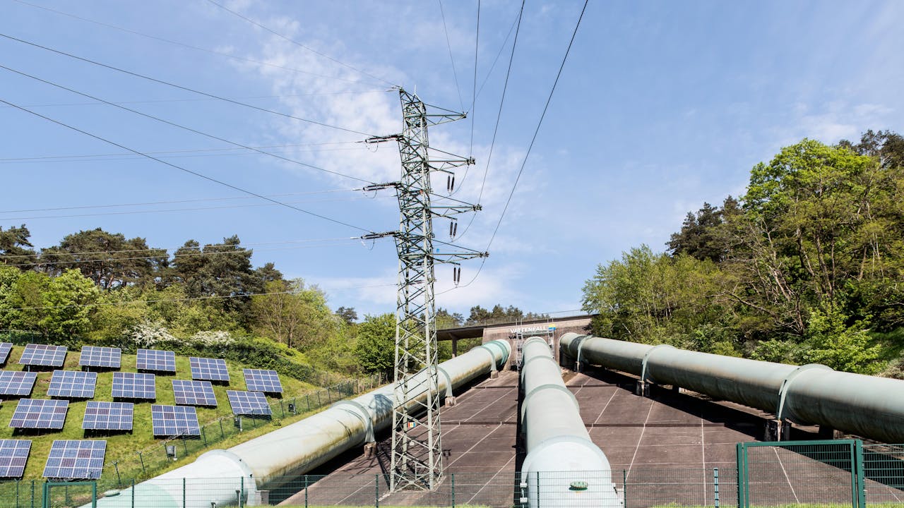Industrial landscape with transmission tower, pipelines, and solar panels in Geesthacht, Germany.