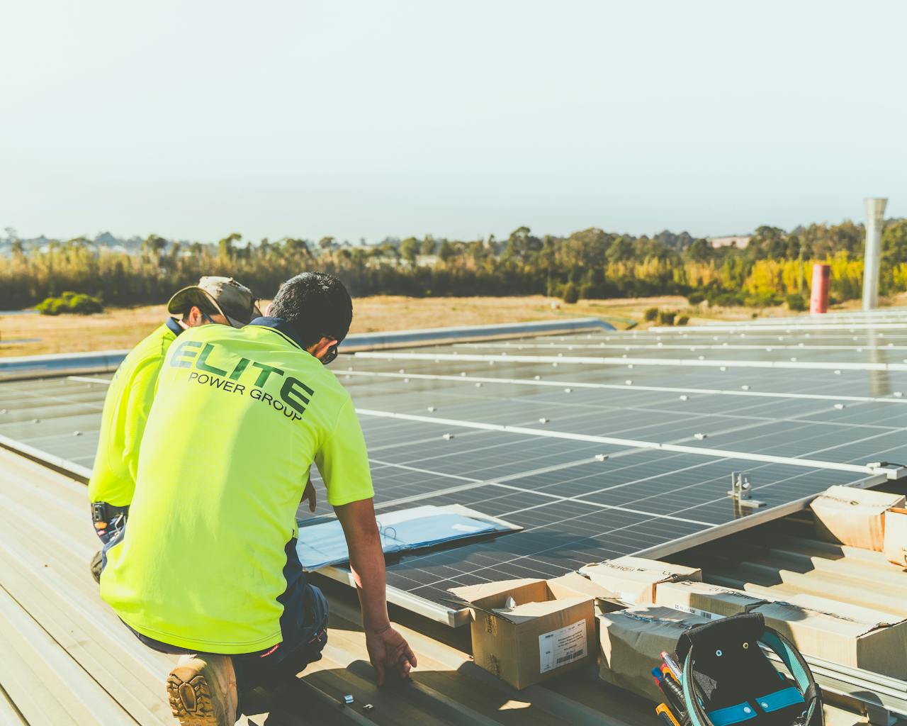 Technicians working on solar panel installation on a rooftop in New South Wales, Australia.